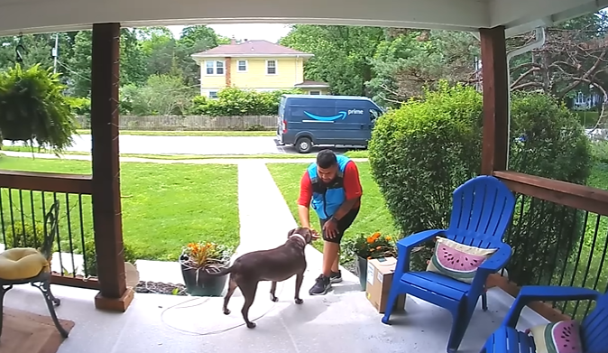 An Amazon driver makes friends with a dog on the front porch. 