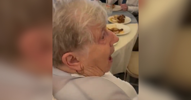 Side-view and close up of a grandmother who looks shocked, mouth open, as she sees her granddaughter chose to wear her dress.