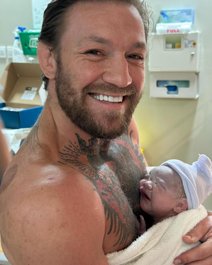 Conor McGregor holds his newborn son. 