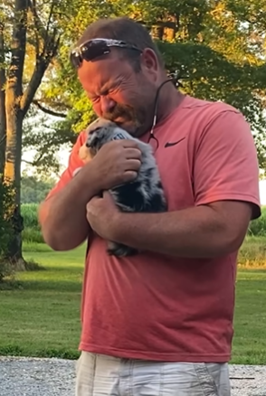 A dad is tearing up over the new puppy in his arms. 