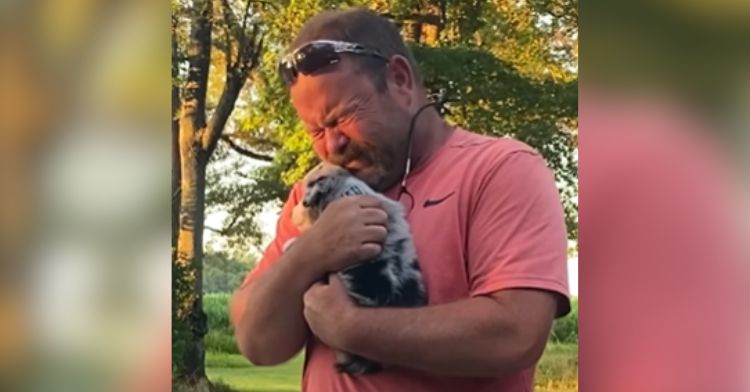 A dad is tearing up over the new puppy in his arms.