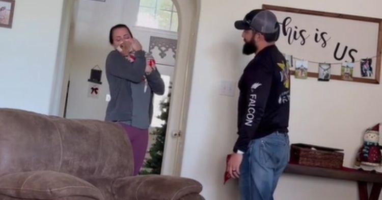 A wife cuddles with the new puppy that her husband surprised her with.