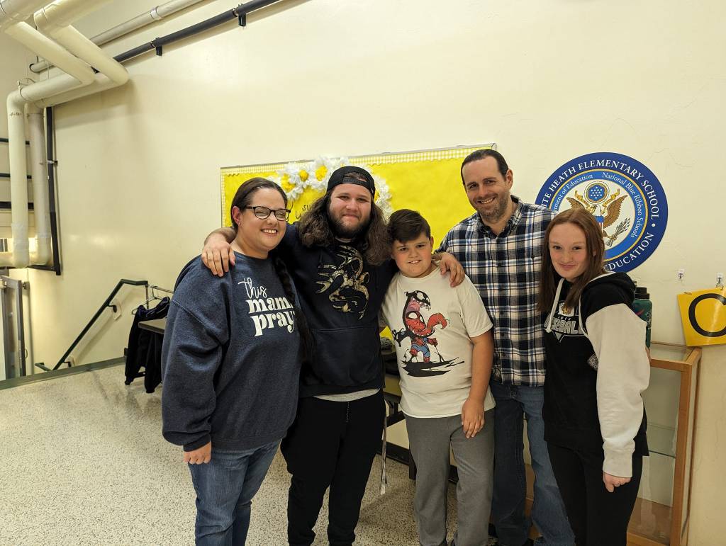 Ian smiles and poses with Daniel and his family, including his mom, dad, and sister.