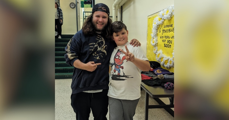 Janitor Ian Greenarch points and smiles at the boy he wrote a letter for, an arm around his shoulder. The boy, Daniel, smiles and gives a peace sign.