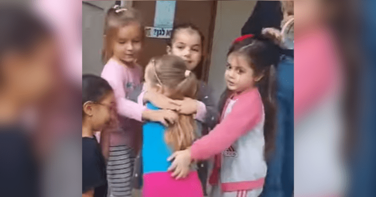 little girl hugging other little kids