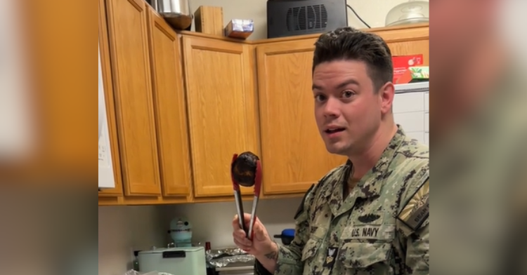 man holds burnt bun with tongs