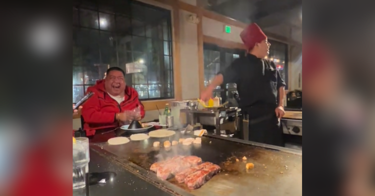 man laughing at hibachi grill with chef