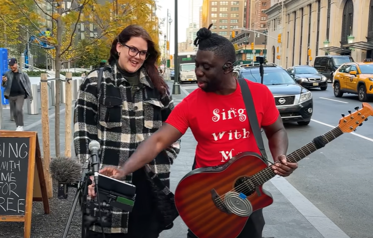 An office worker sings on the street with a famous YouTuber. 