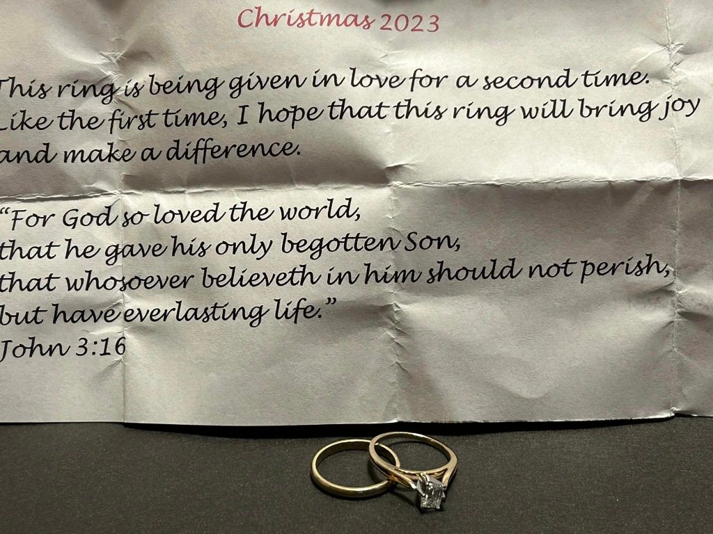 Note from a widow that reads: 

Christmas 2023.

This ring is being given in love for a second time. Like the first time, I hope that this ring will bring joy and make a difference.

"For God so loved the world, that he gave his only begotten Son, that whoever believeth in him should not perish, but have everlasting life."
John 3:16

Below the note is a wedding band and engagement ring with a square diamond.