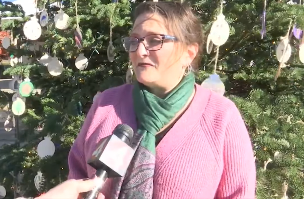 Dr. Marie Bordeleau, principal of St. Hilary School, stands outside and talks into a news mic.