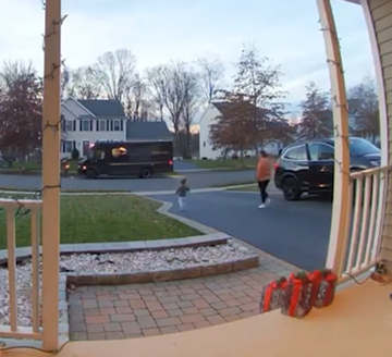 A little boy runs across the street to greet the UPS driver. 