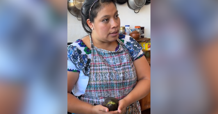 woman holding avocado