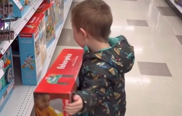 Kid putting toy back on the shelf after dad said no.