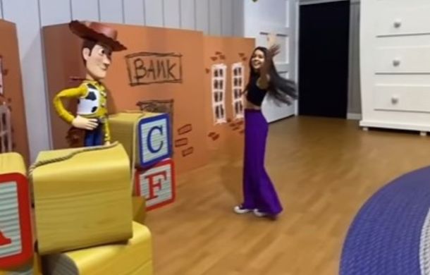 A visitor to the life-sized Toy Story room in Madrid, Spain poses near Sheriff Woody.