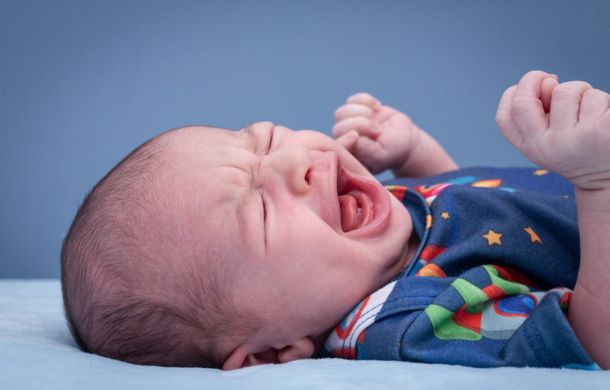 Stock image of a crying infant being left alone to cry-it-out as described in the neighbor note.