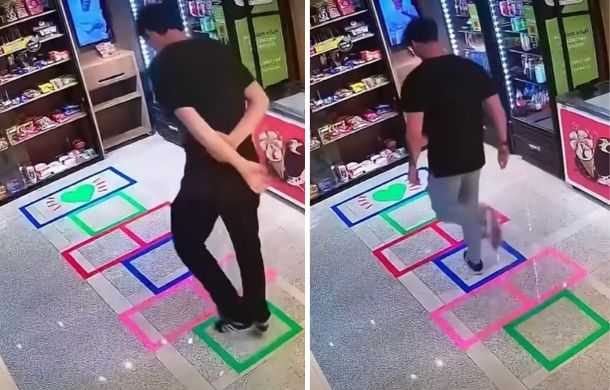 The same store, with a hopscotch board laid out on the tile floor. A grown man is jumping along the squares.