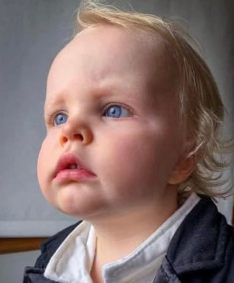 A young boy with blue eyes looking into the distance. 