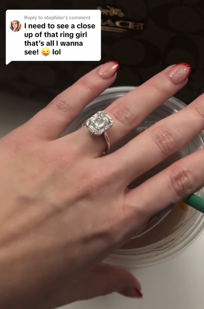 Close up of Angela Gayle's large, rectangle diamond ring as she goes to grab a cup. 

A TikTok comment on the image reads: I need to see a close up of that ring girl that's all I wanna see! lol