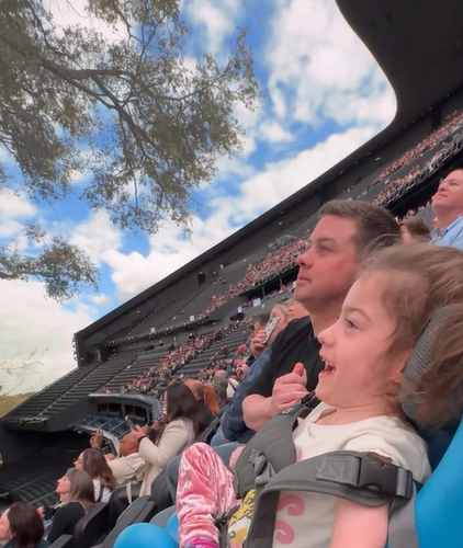 Girl with cerebral palsy smiles, mouth open, as she admires the sights inside the Las Vegas Sphere.