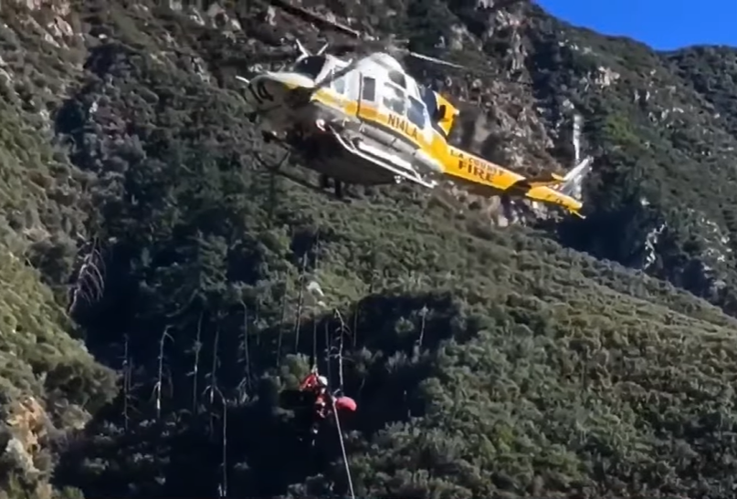 View of a helicopter airlifting a California woman after she plummeted 200 ft. down a cliff.