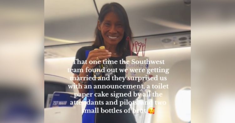 A smiling flight attendant holding a fake cake made of toilet paper.