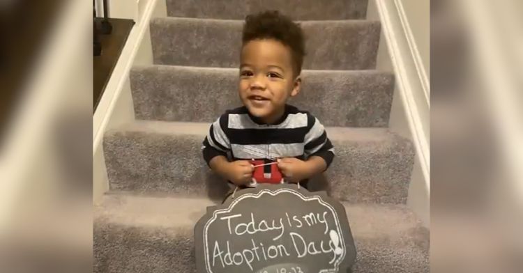 A toddler holding a sign that reads, "Today is my Adoption Day!"