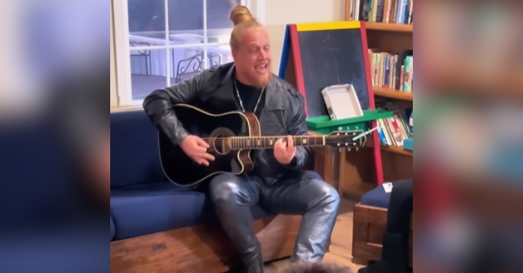 Huntley, latest winner of "The Voice," closes his eyes as he sits on a couch, plays a guitar, and sings for homeless families in Loisann's Hope House.