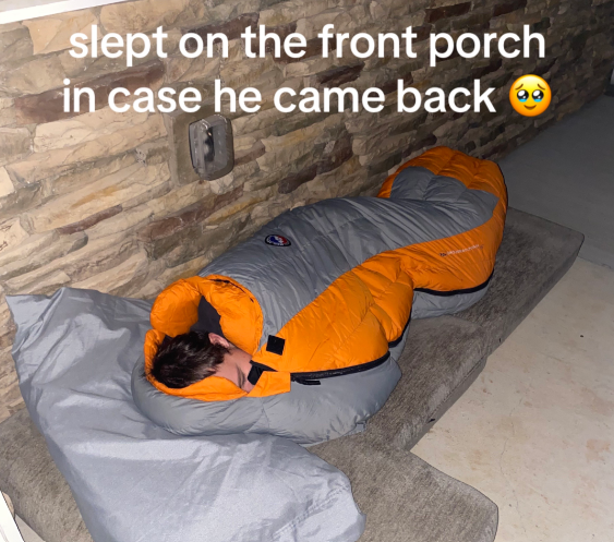 View of Tiffany Bates' husband sleeping outside their home in a sleeping bag. Couch cushions have been placed on the ground to make it more comfortable. Her husband is waiting for their lost cat to come back.

Text on the image reads: Slept on the front porch in case he came back