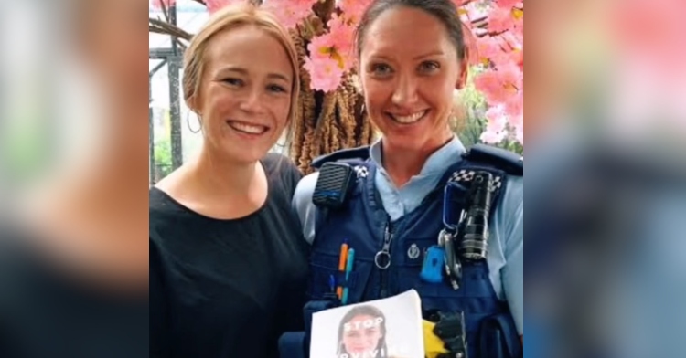 Jazz Thornton smiles and poses with Constable Meika Campbell, the woman who helped save her life. In Meika's hand is a copy of Thornton's book, "Stop Surviving Start Fighting."