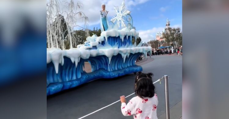 A deaf little girl watches a parade at Disneyland.