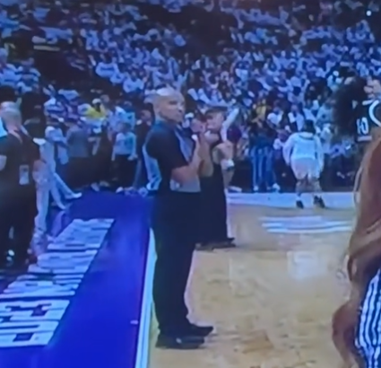 A ref for the NBA gets ready to send a secret signal to his wife on television. 