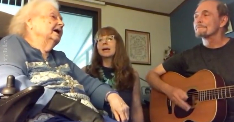 Gary Talley plays guitar as his 93-year-old mom, Nita Talley, and a young woman sing "One Day at a Time" together.