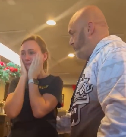 A pregnant waitress cries after receiving a generous tip. 