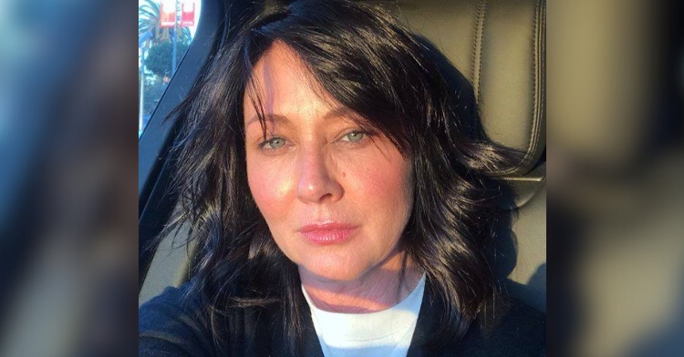 Shannen Doherty makes a serious face as she poses for a selfie in a car.