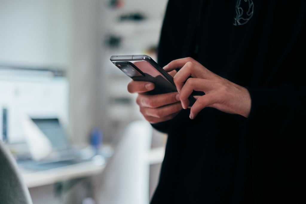 A man in need of a digital detox using his smartphone.