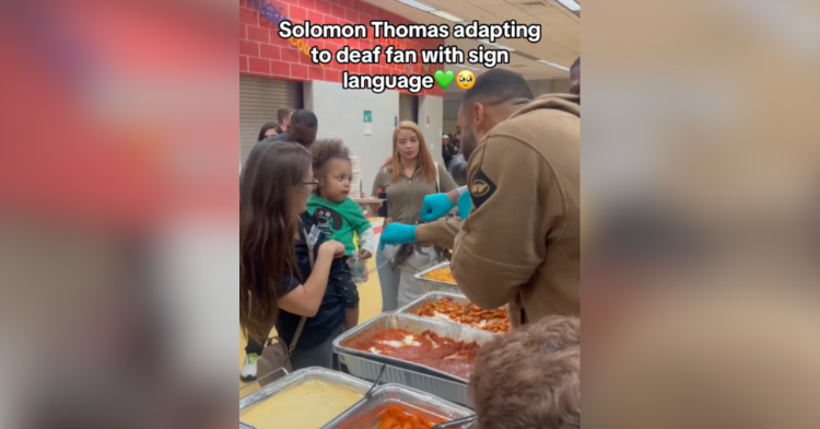 solomon thomas speaking to a toddler via sign language