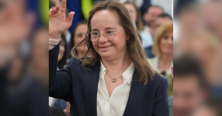 Mar Galcerán, newly appointed member of the Spain parliament, smiles as she raises her hand.