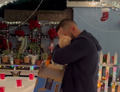 A man hugs the teddy bear he received as a gift.