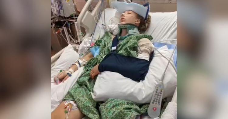 Kennedy Littledike lays in a hospital bed, not awake. Her leg has been amputated, an arm is in a crutch, and she's hooked up to machines.