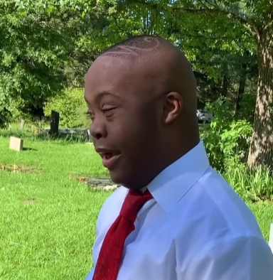 A young man with Down syndrome visits his mom's grave. 