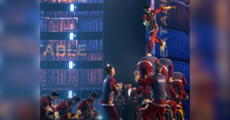 V.Unbeatable performs on the "America's Got Talent: Fantasy League" stage. A man is mid-air as he leaps down a line of men who are balancing on motorcycles.