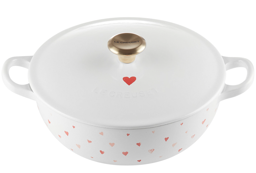 A Le Creuset L’Amour Cast-Iron Soup Pot. On the pot are red hearts of various shapes and hues of red. There's a single, larger red heart on the lid.