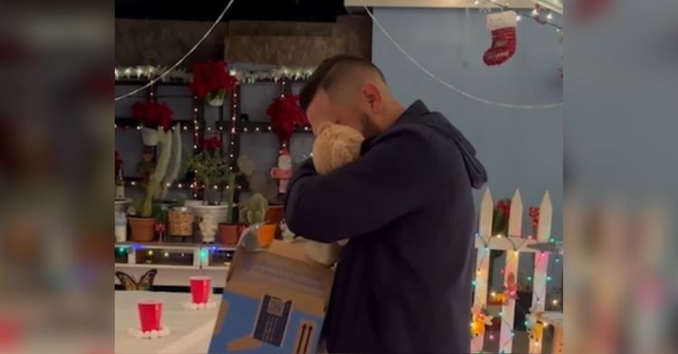 A man hugs the teddy bear he received as a gift.
