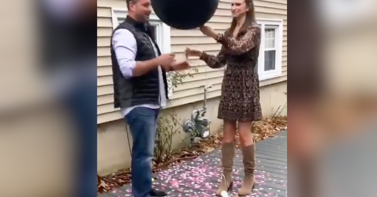 women pops gender reveal balloon