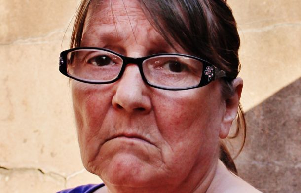 Image shows a sad older woman.