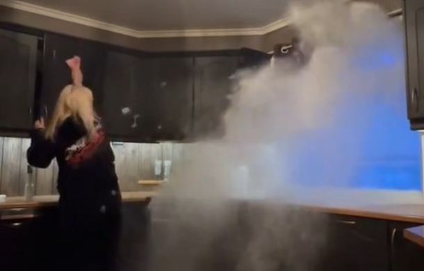 As this Norwegian housewife cleans, her husband is outside the open window operating a snowblower.