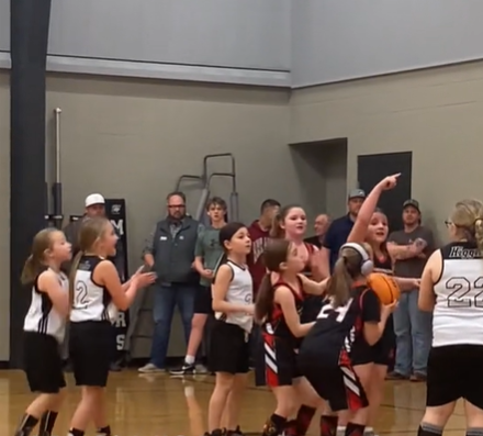 A girl with Down syndrome prepares to sink an important shot on the basketball court.