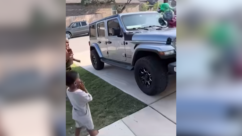 little boy looks in surprise at jeep with balloons tied to it