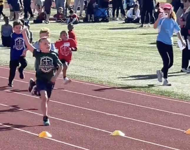 child waves during a race