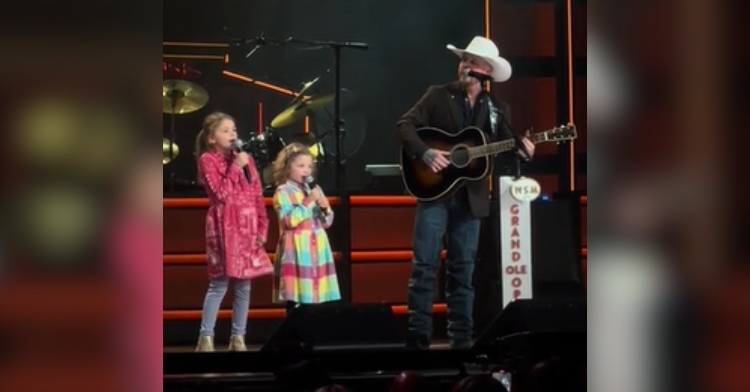 Cody Johnson and his two daughters sing "My Rifle, My Pony, and Me" together on the Grand Ole Opry stage.